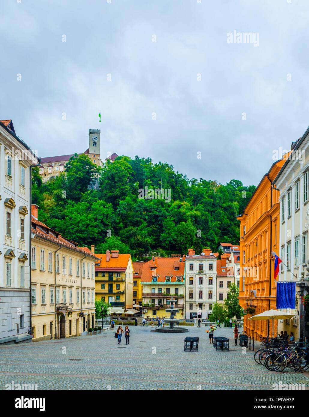 LJUBLJANA, SLOWENIEN, 29. JULI 2015: Novi trg - Neuer Stadtplatz in der slowenischen Hauptstadt Ljubljana wird von einer auf einem Hügel gegenüberliegenden Burg überragt Stockfoto