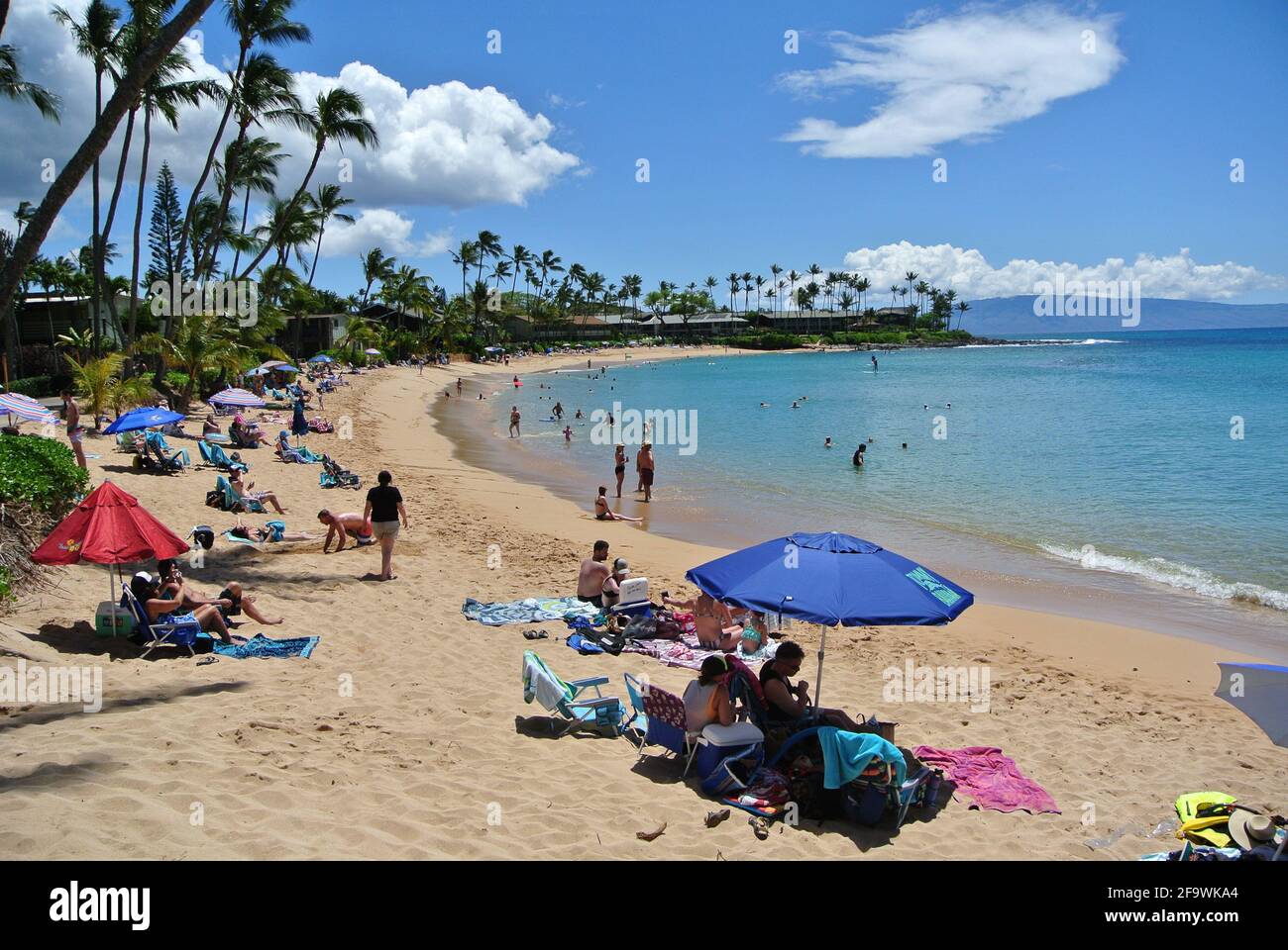Touristen entspannen sich unter Sonnenschirmen und schwimmen und spielen auf der Sonniger Sandstrand von kaanapali westlich der Stadt Lahaina Auf der Insel Maui Hawaii usa Stockfoto
