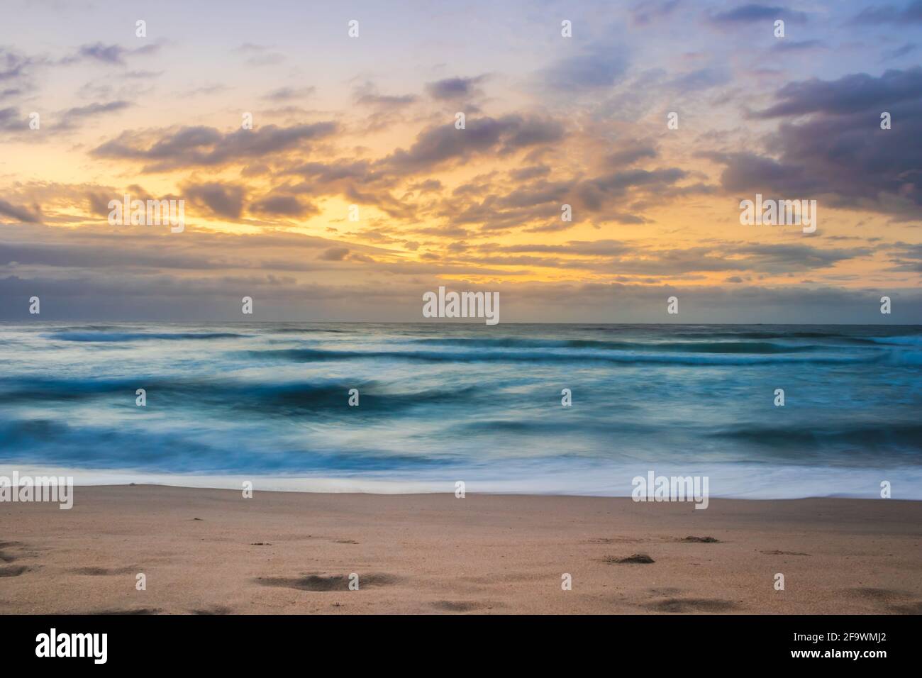 Wolkiger Sonnenaufgang über dem rauen Indischen Ozean von einem Aussichtspunkt auf einem Strand in Port Shepstone, Kwa-Zulu Natal, Südafrika Stockfoto