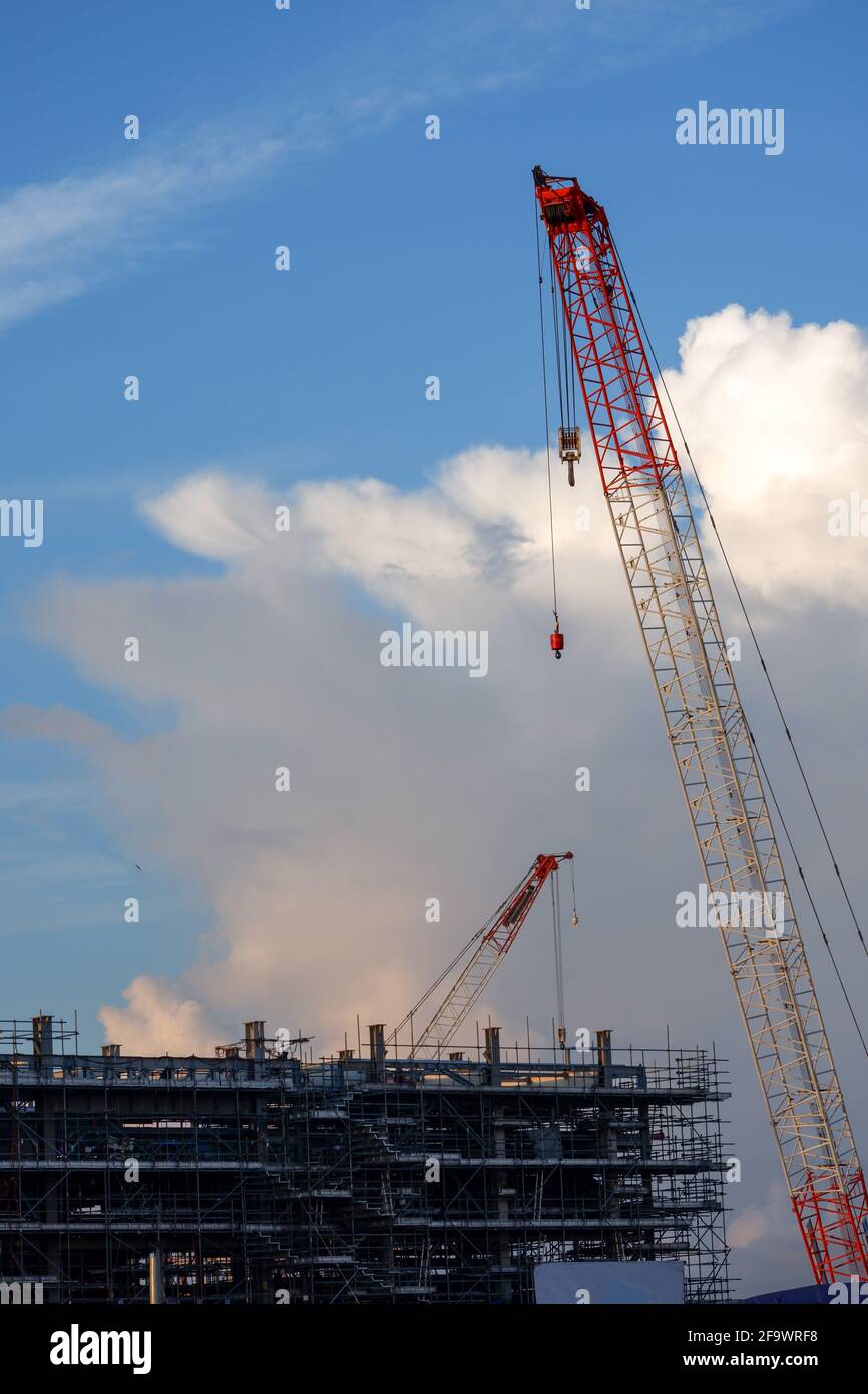 Bau Turmkran der Kran ist von Gerüsten mit schönen Wolken im Hintergrund umgeben. Stockfoto