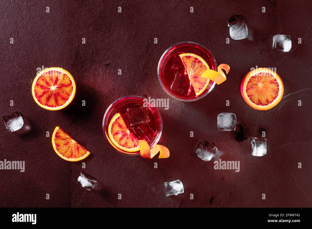 Negroni Cocktails, getöntes Bild. Blutorangen, Gläser mit Orangenschale Stockfoto