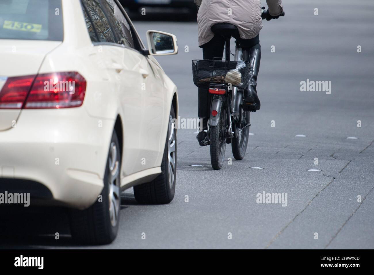 Mainz, Deutschland. April 2021. Ein Auto fährt dicht hinter einem Radfahrer. Der Trend zu Fahrrädern und E-Bikes, der während der Corona-Pandemie deutlich zunahm, stellt die fünf größten Städte in Rheinland-Pfalz vor eine Herausforderung. Laut einer dpa-Umfrage sollte der Anteil des Radsports am Verkehr überall erhöht werden. (To dpa 'Überholverbot und Parkhaus: Städte bereiten sich auf den Fahrradboom vor') Quelle: Sebastian Gollnow/dpa/Alamy Live News Stockfoto