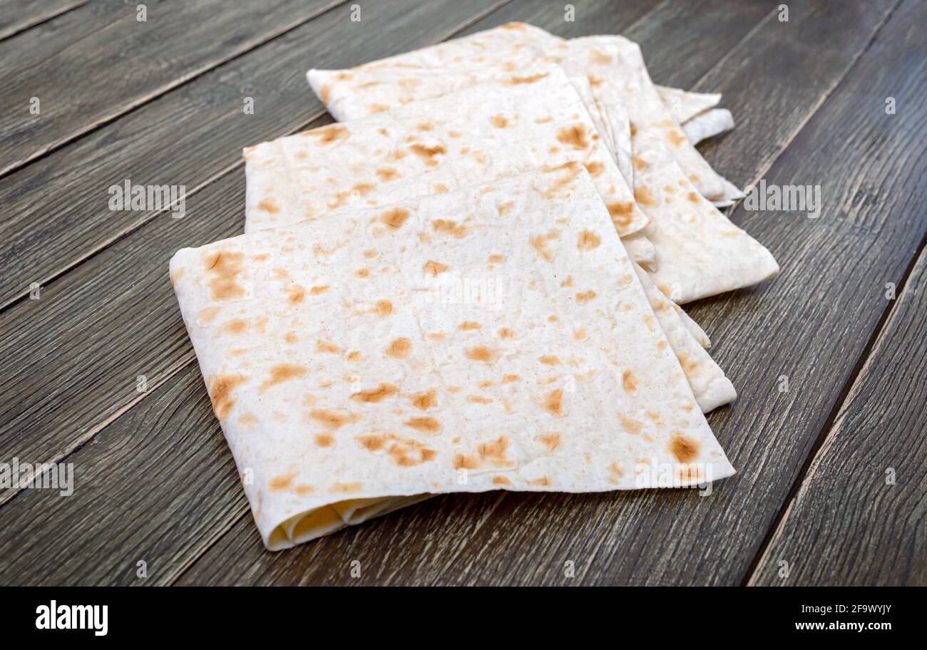 Dünnes Pita-Brot auf Holzhintergrund. Lavasch - leckeres herzhaftes gesundes armenisches und türkisches ungesäuertes Fladenbrot. Stockfoto