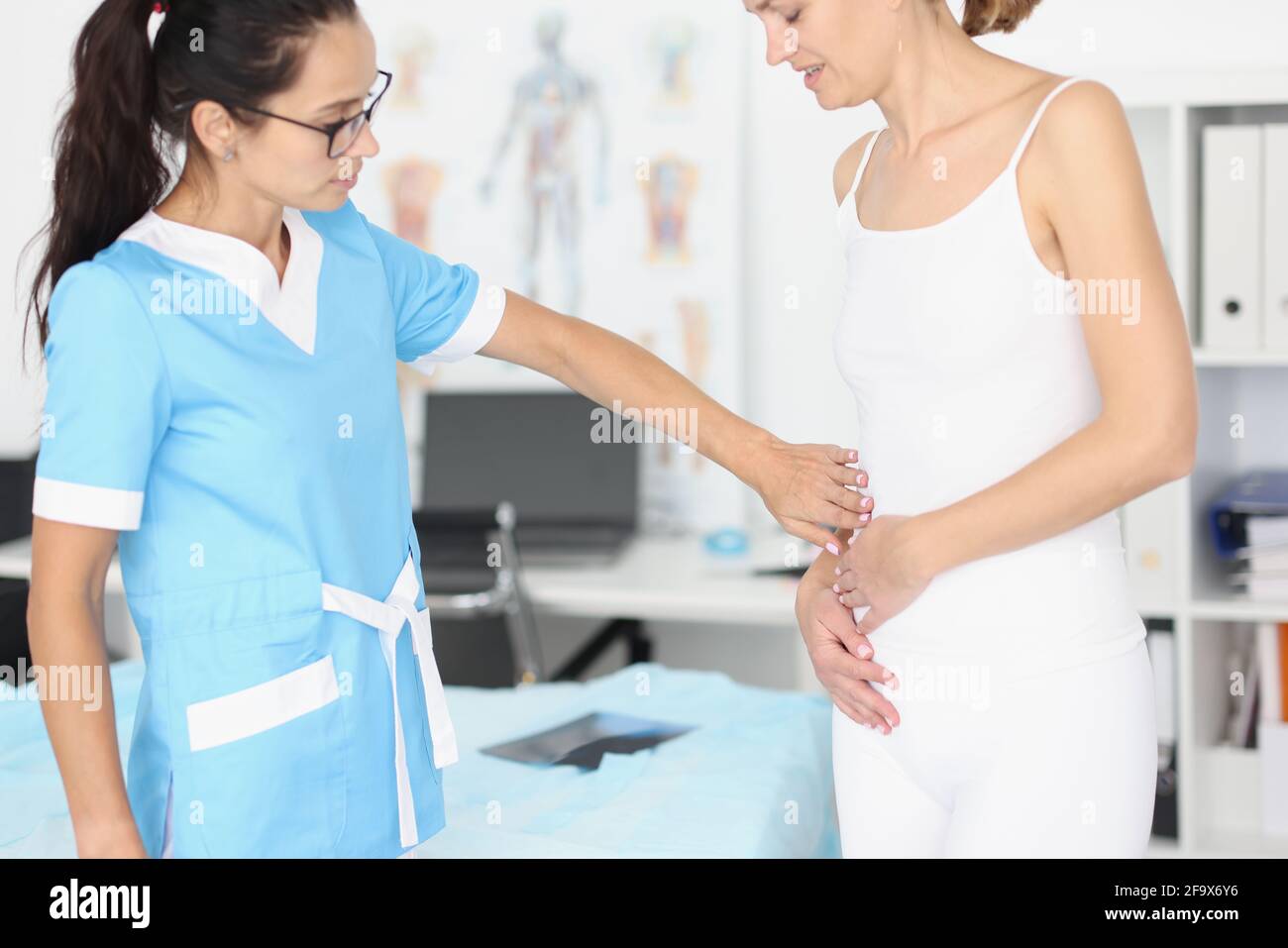 Gynäkologe Arzt klopfen kranken Bauch der jungen Frau Stockfoto
