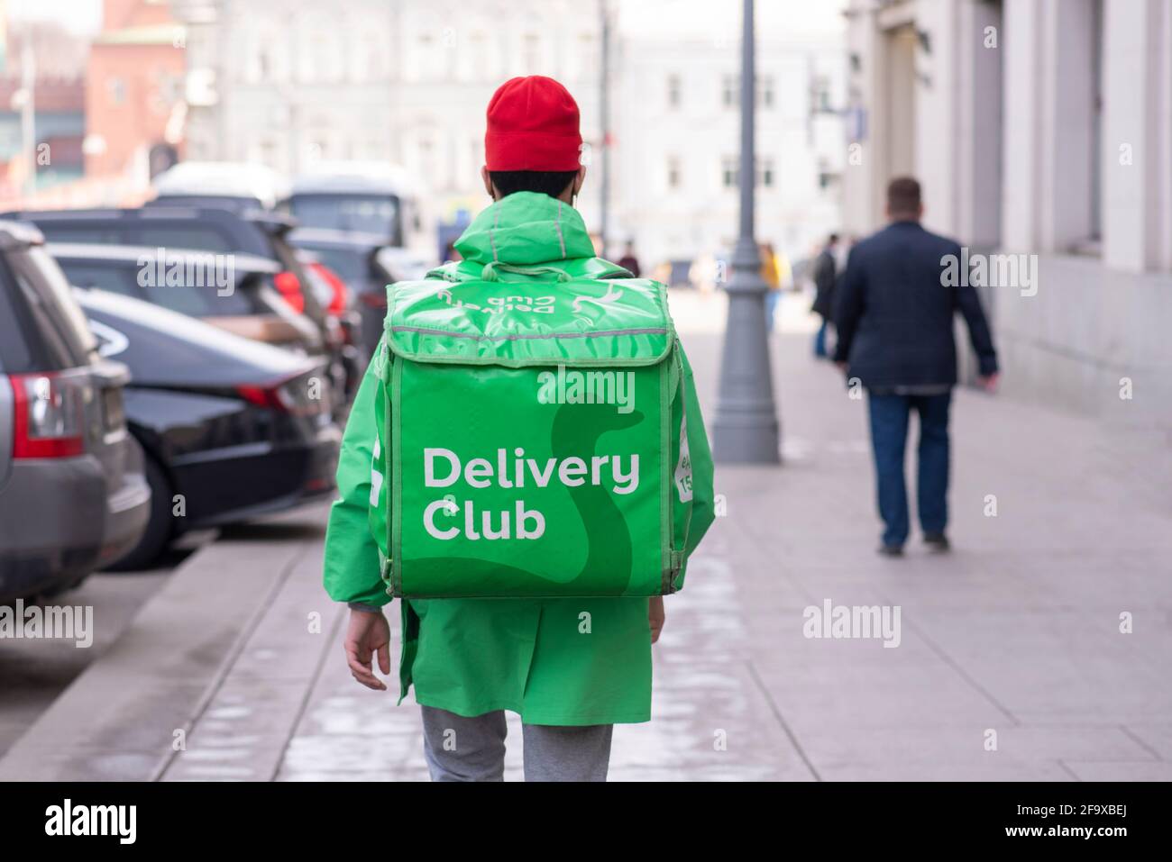 MOSKAU - APR 13: Delivery Club Company Kurier mit grüner Tasche geht in Moskau mit Auftrag, April 13. 2021 in Russland Stockfoto