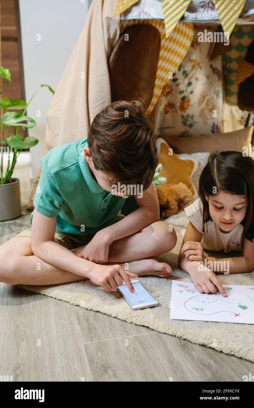 Junge und Mädchen spielen Schatzsuche Spiel in einem Zelt Zu Hause Stockfoto