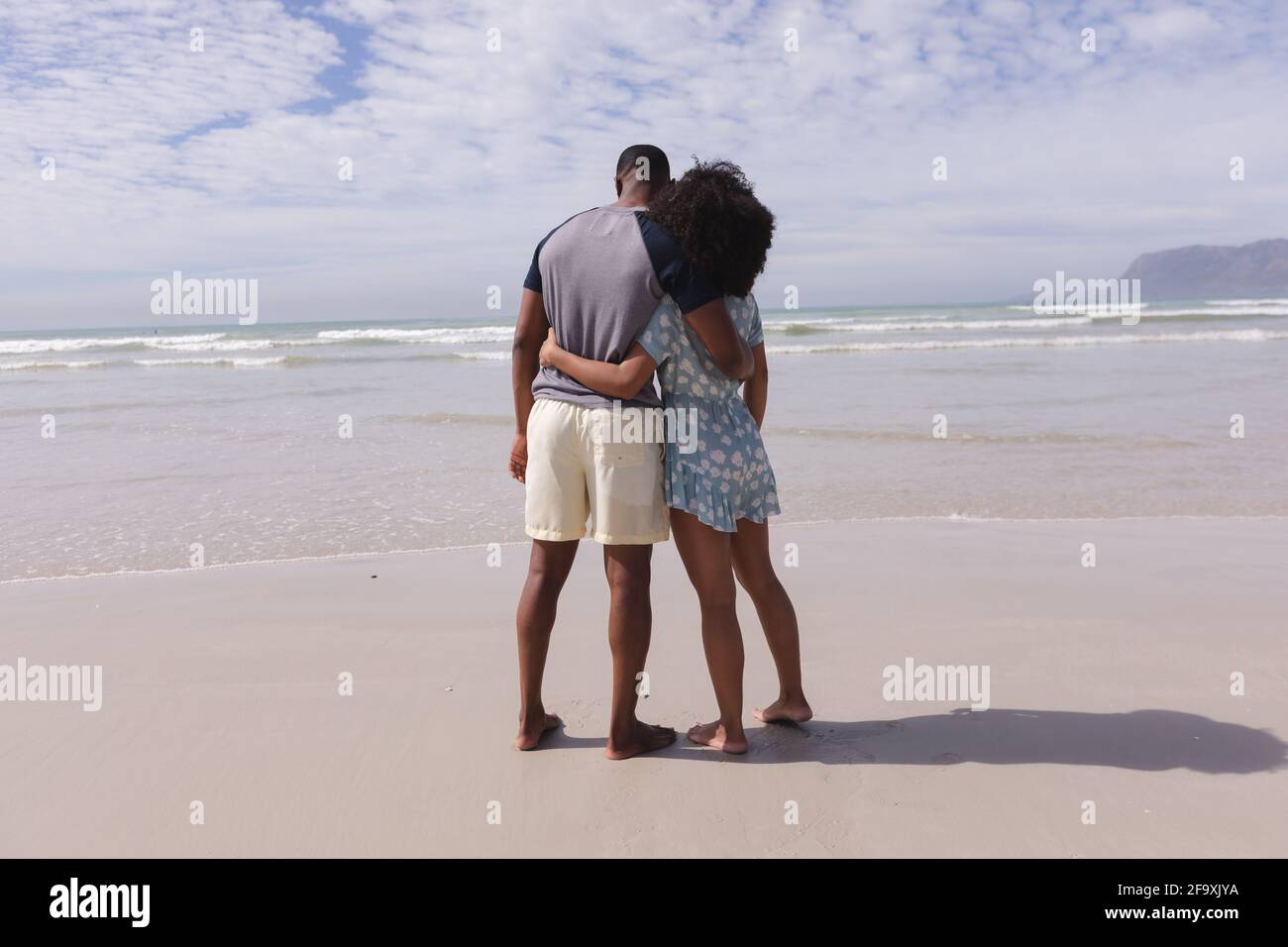 afroamerikanisches Paar, das am Strand steht und umarmt Stockfoto
