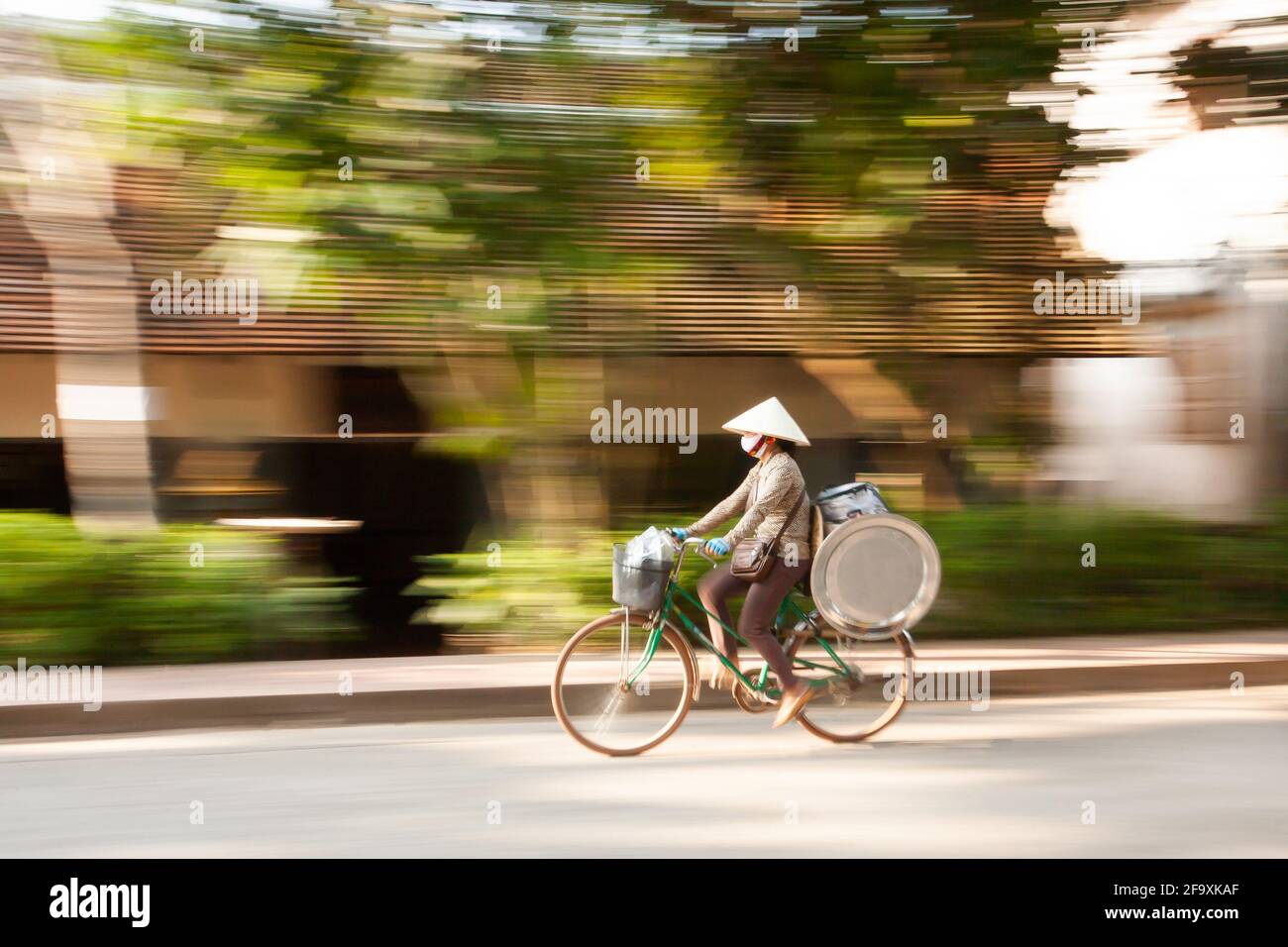 Laotische Verkäuferin auf der Straße von Luang Prabang, Laos, auf dem Fahrrad mit Edelstahl-Tablett. Stockfoto
