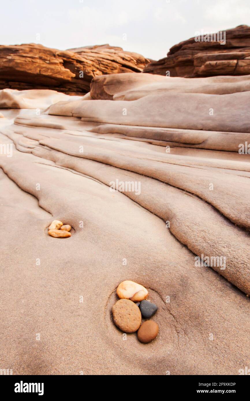 Zen-Meditation in der Natur. Abstrakte Kies und Wellen in steilem Sandstein, Balance und Harmonie. Steillandschaft am Mekong Riverbank im Sommer. Stockfoto