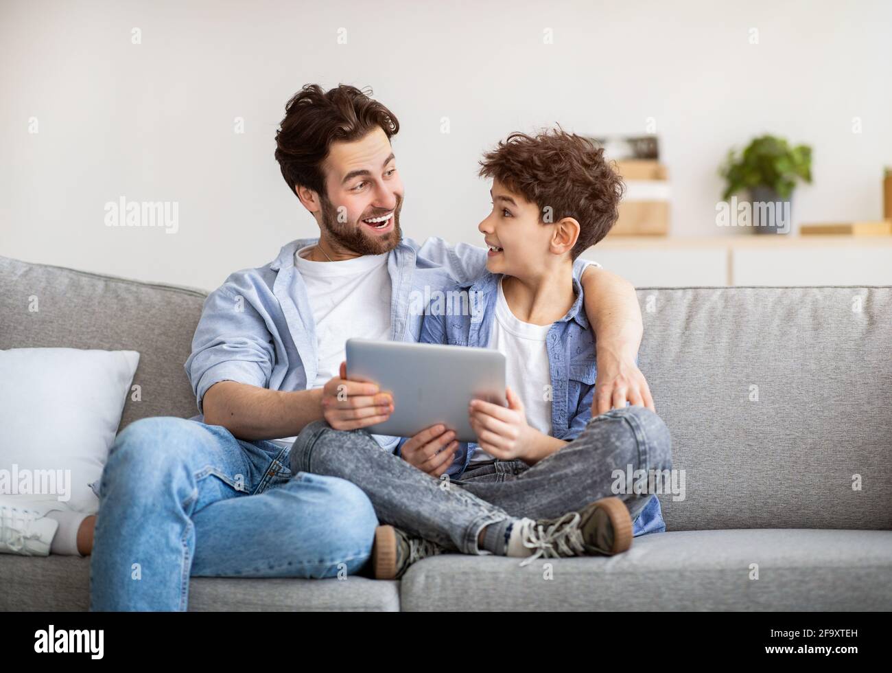 Familienwochenende. Vater und Sohn wurden mit einem Tablet-Computer excoted, surfte im Internet, während sie zu Hause Zeit miteinander verbrachten Stockfoto