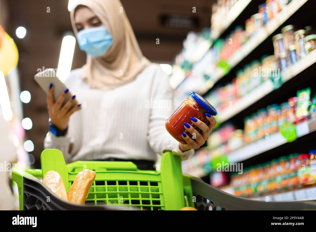 Muslimische Dame Mit Telefonkauf Und Scannen Von Lebensmitteln Im Supermarkt Stockfoto