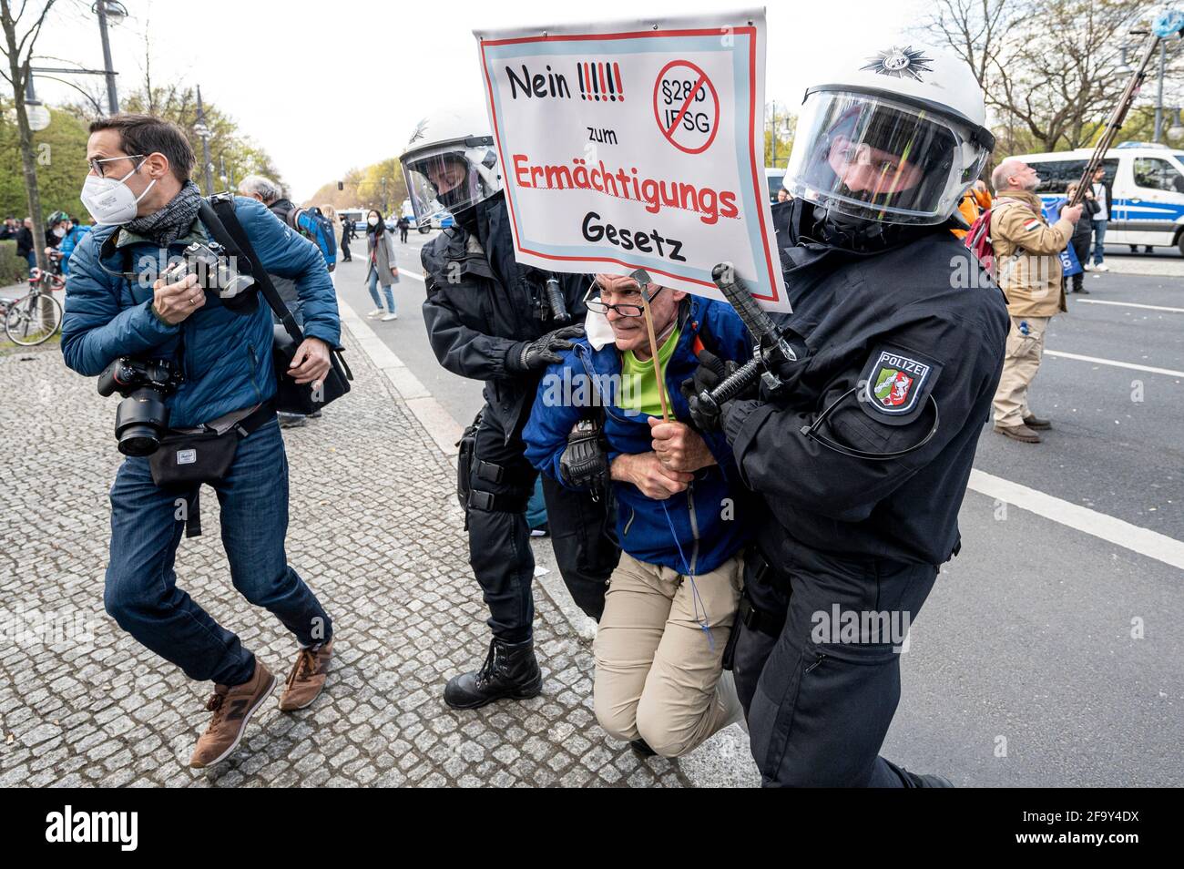 Berlin, Deutschland. April 2021. Ein Demonstrator mit einem Schild mit der Aufschrift „Nein zum Ermächtigungsgesetz“ wird von den Polizeikräften auf der Straße des 17 mitgenommen. Juni. Die Demonstranten protestieren gegen die Corona-Beschränkungen und die Änderung des Infektionsschutzgesetzes. Der Bundestag beschäftigt sich heute in seiner Sitzung mit dem Thema und will eine bundesweite Corona-Notbremse bestehen. Quelle: Fabian Sommer/dpa/Alamy Live News Stockfoto