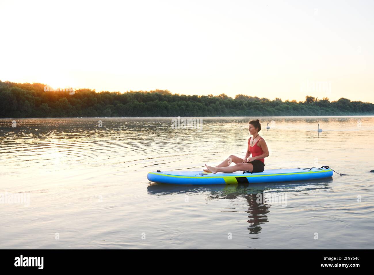 Genießen Sie die Morgensonne auf einem Paddleboard Stockfoto
