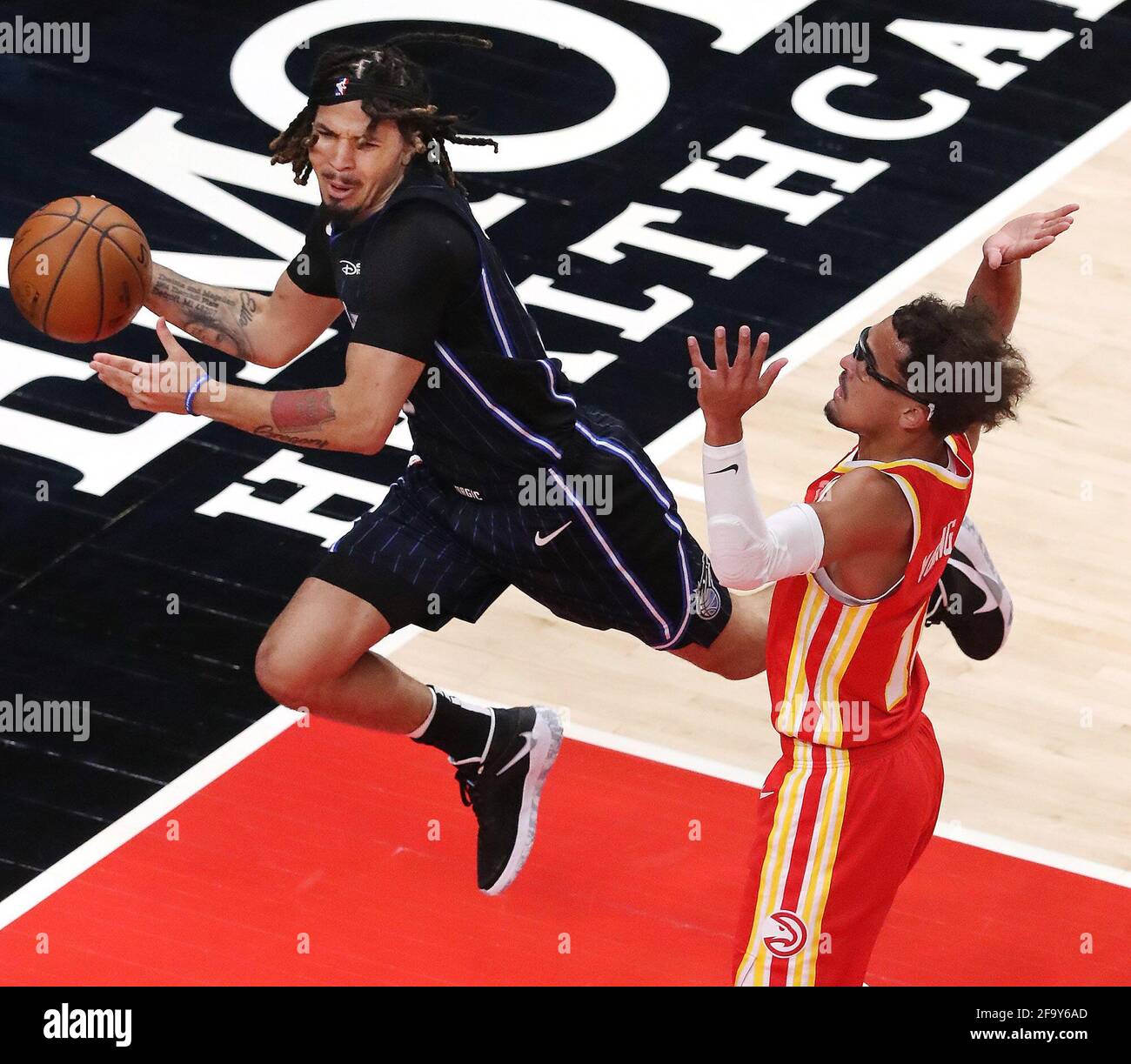 Atlanta, USA. April 2021. The Atlanta Hawks' Trae Young, rechts, schaufelt Cole Anthony des Orlando Magic auf seinem Weg zum Korb am Dienstag, den 20. April 2021, in der State Farm Arena in Atlanta. (Foto von Curtis Compton/Atlanta Journal-Constitution/TNS/Sipa USA) Quelle: SIPA USA/Alamy Live News Stockfoto