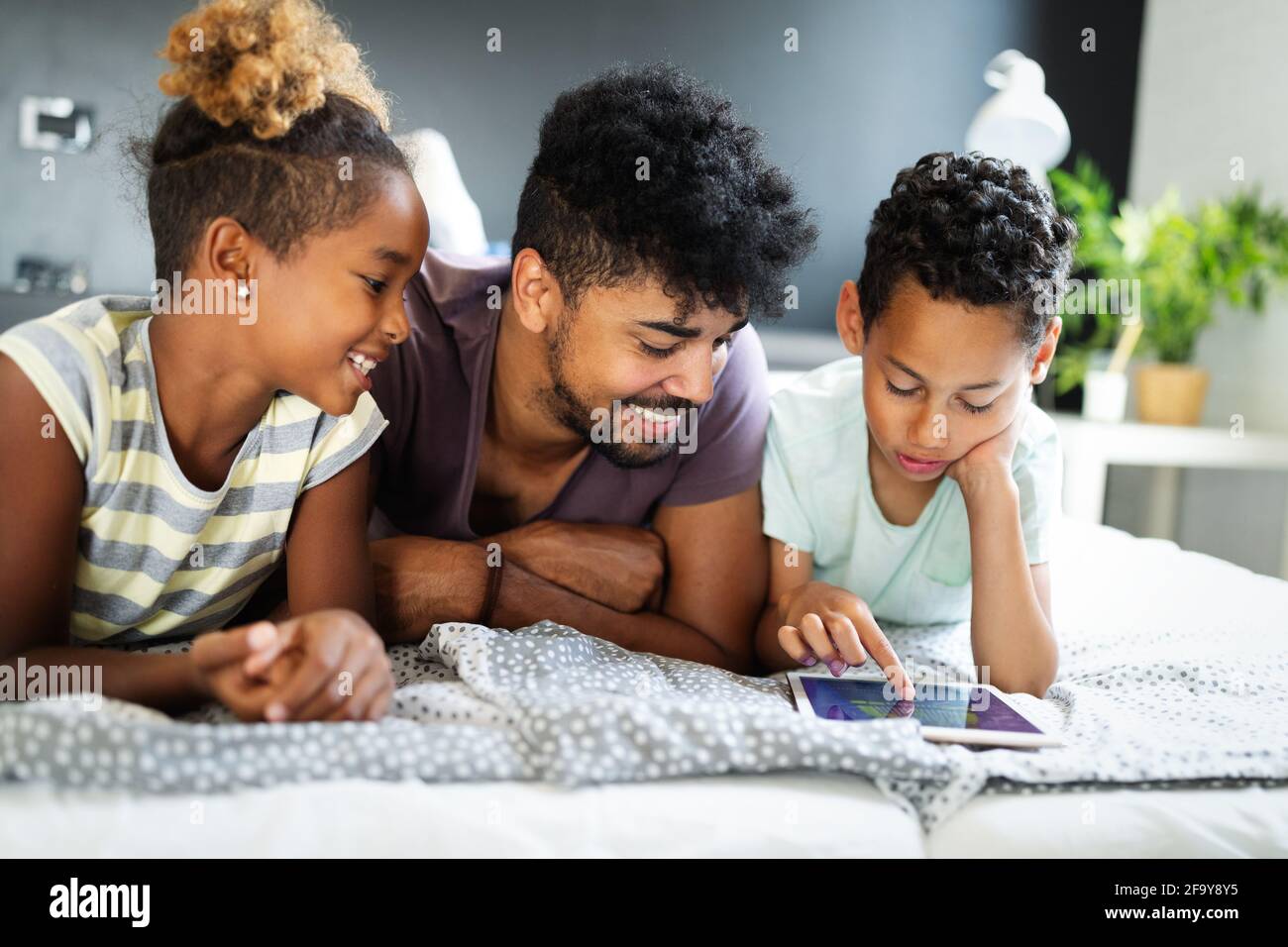 Glücklicher Vater und Kinder Spaß mit Tablet, lächeln auf lustige Video, Spiel spielen Stockfoto