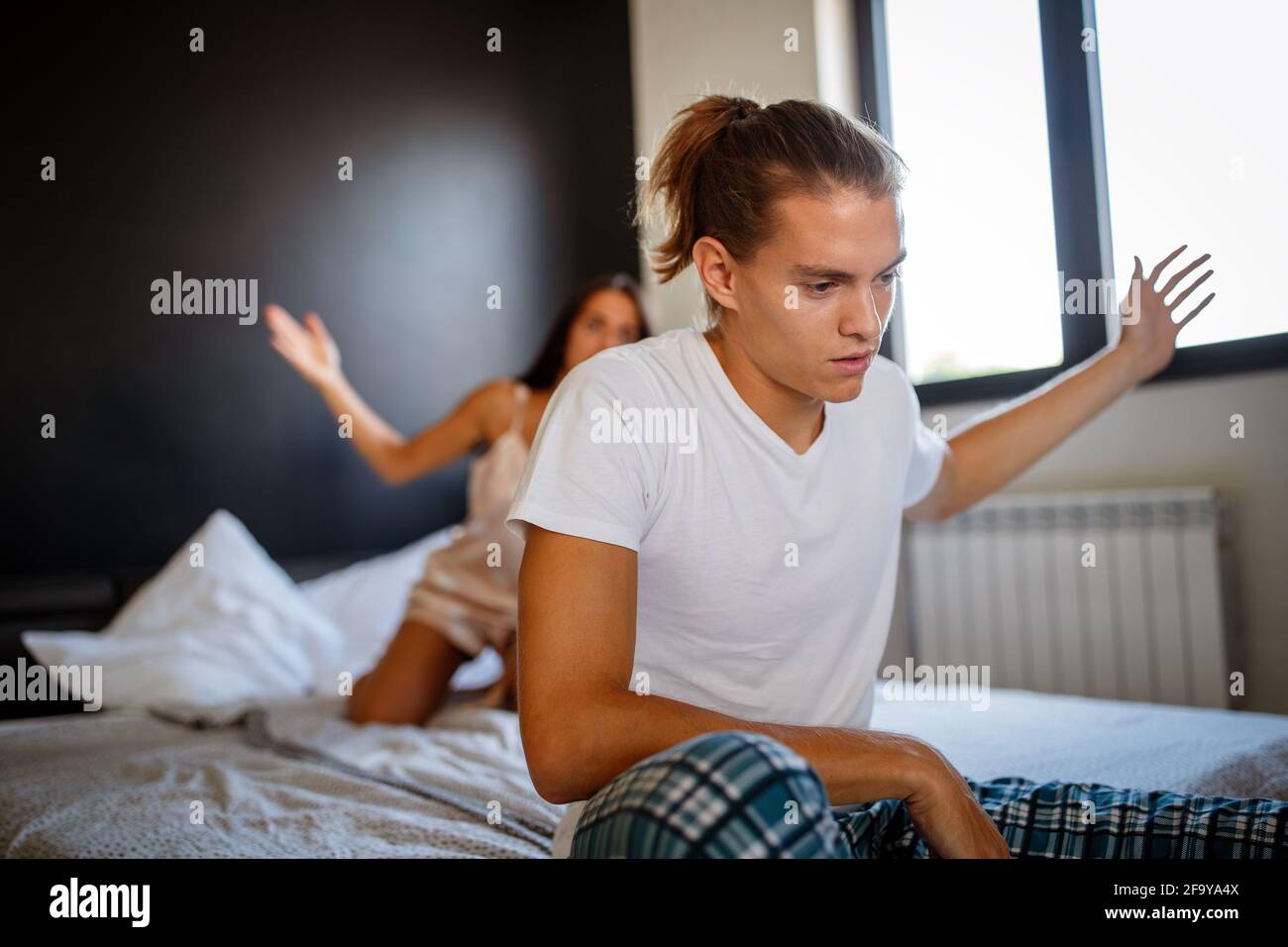 Junges Paar im Bett mit Problemen und Krise. Scheidung und Trennung Stockfoto