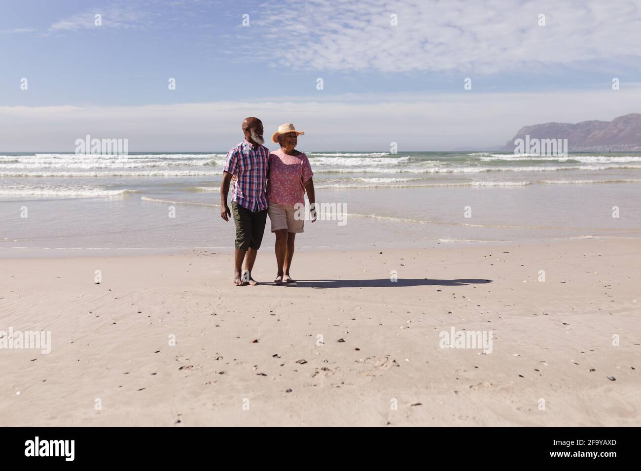 Glückliches afroamerikanisches Senioren-Paar, das am Strand zusammen läuft Stockfoto
