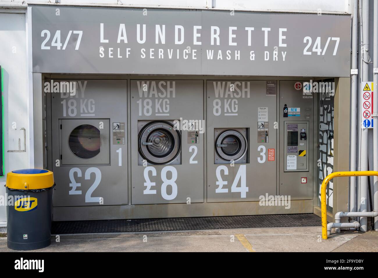 Selbstbedienungswaschmaschine 24/7 an einer Tankstelle in Hawkwell, Essex, Großbritannien. Automatische, automatisierte Waschmaschinen für Kleidung, draußen, auf dem Garagenvorplatz Stockfoto
