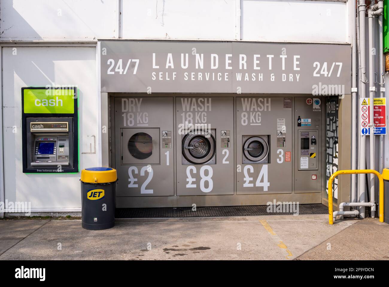 Selbstbedienungswaschmaschine 24/7 an einer Tankstelle in Hawkwell, Essex, Großbritannien. Automatische, automatisierte Waschmaschinen für Kleidung, draußen, auf dem Garagenvorplatz Stockfoto
