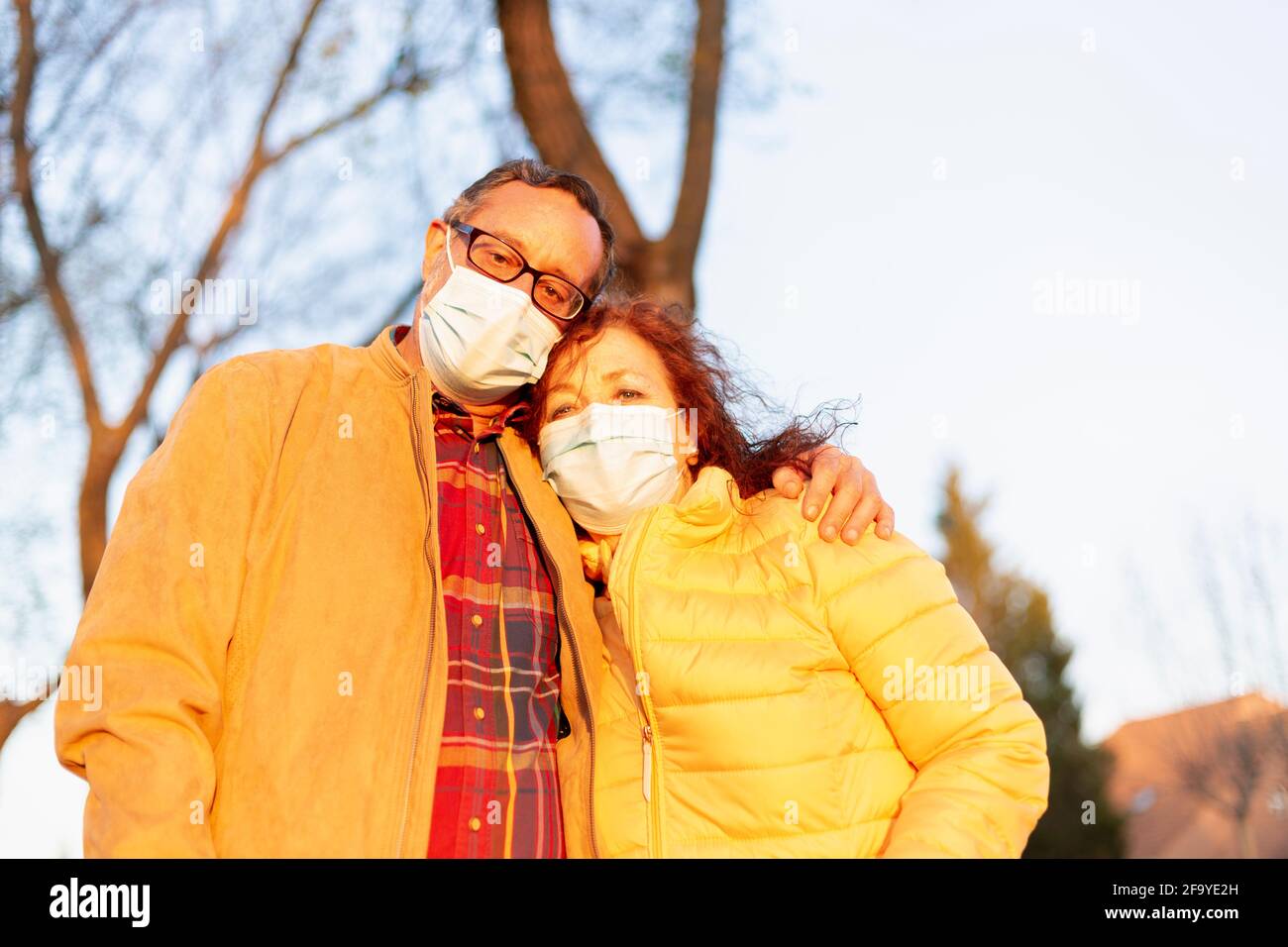 Älteres Paar mit Gesichtsmaske. Sie umarmen sich im Freien. Konzept der Einheit gegen das Covid-19-Virus. Stockfoto