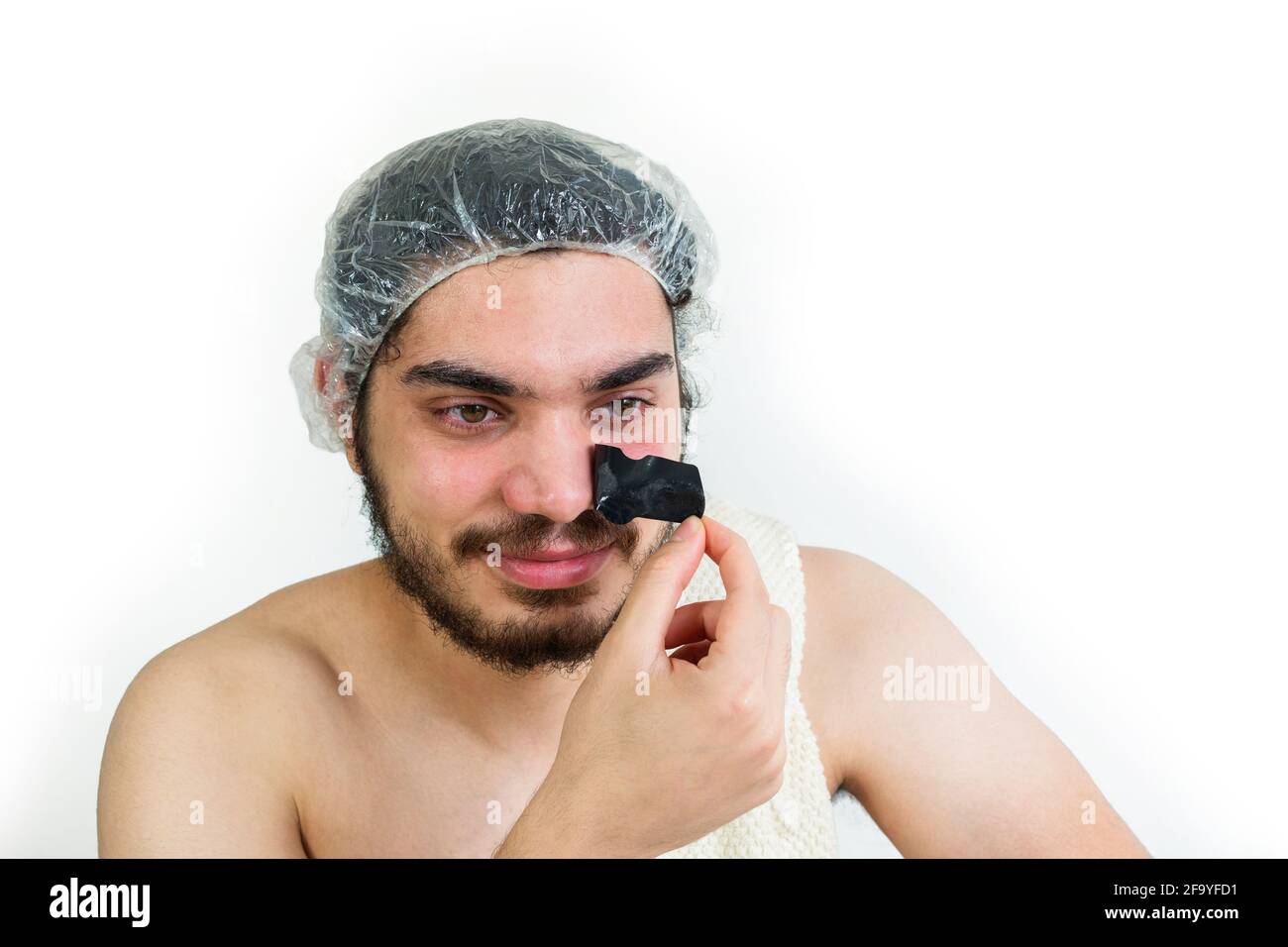 Nahaufnahme eines jungen jüdischen Mannes, der einen Schwarzen entfernt hat Maske auf der Nase Stockfoto