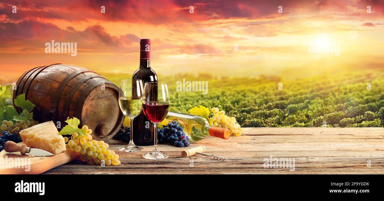 Barrel Weingläser Käse Und Flasche In Vineyard Bei Sonnenuntergang Stockfoto