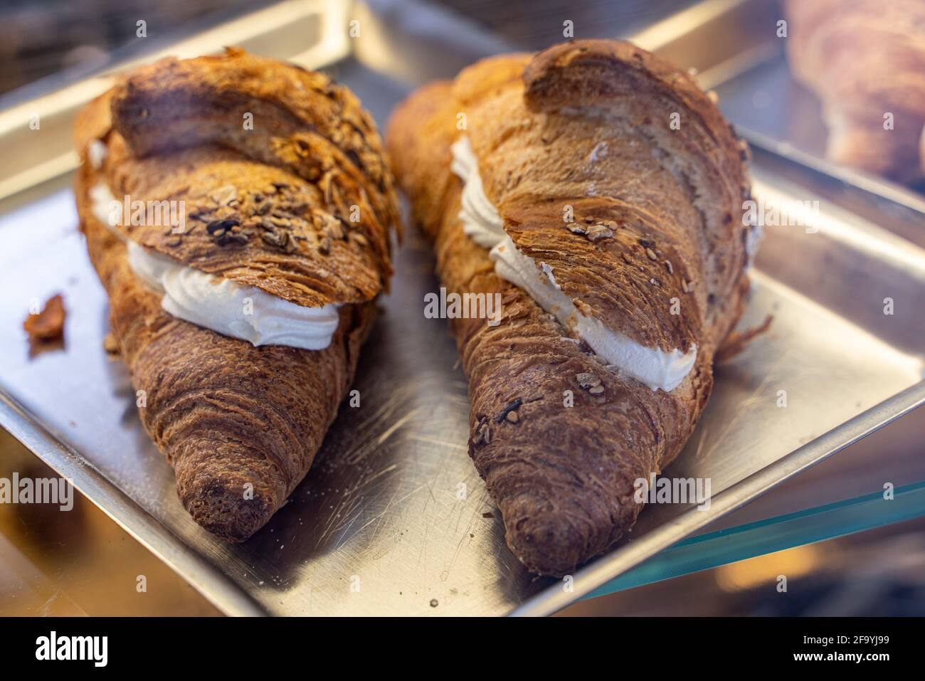 Vollkorncroissants gefüllt mit Creme auf einem Stahltablett. Frühstück an der Bar. Umbrien, Italia, Europa Stockfoto