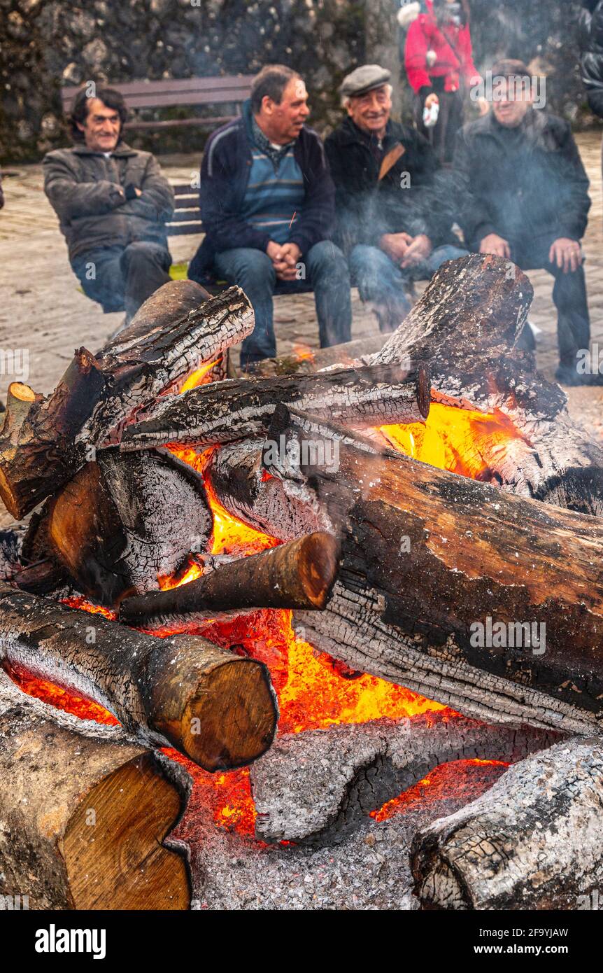 Vier ältere Menschen sitzen auf der Bank vor dem Feuer, das zu Ehren von Sant'Antonio Abate angezündet wurde. Villavallelonga, Provinz l'Aquila, Abruzzen, Ital Stockfoto