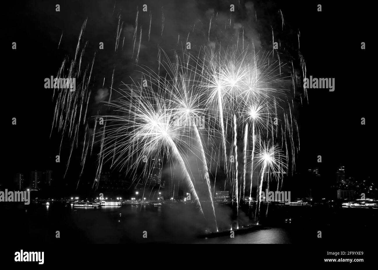 Fantastisches Feuerwerk explodiert in einem Nachthimmel über dem bay in Schwarzweiß Stockfoto