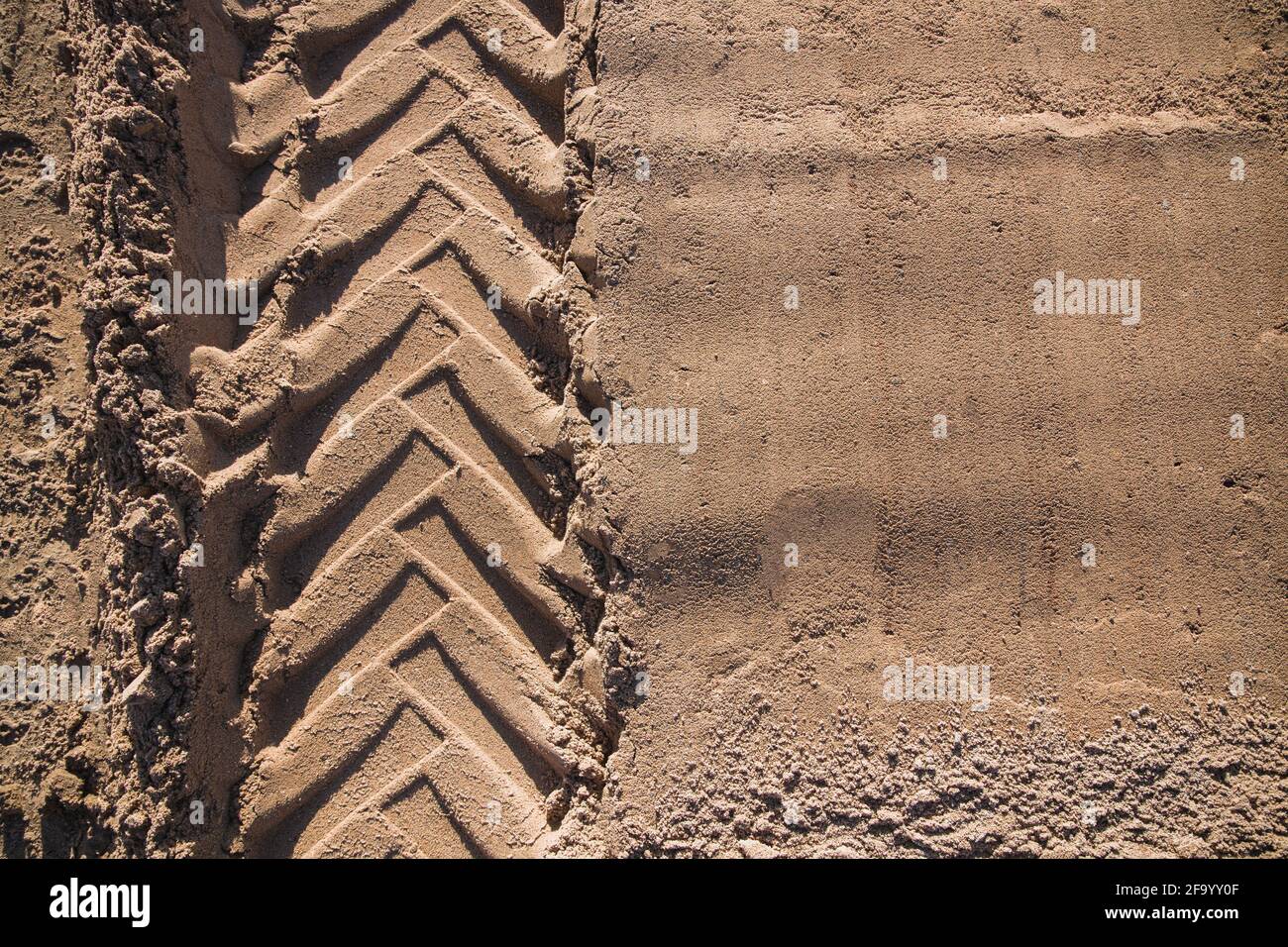Sand mit Traktorrad-Profil auf ihm für Ihre Kreativität Oder Desktop-Hintergrund Stockfoto