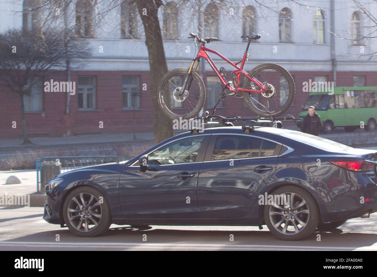 Fahrrad auf dem Dach des fahrenden Autos auf der Stadtstraße Stockfoto