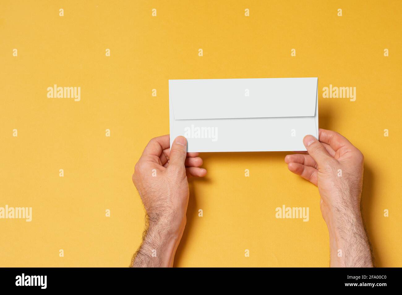 Männliche Hand mit Briefkopfpapier-Umschlag, bearbeitbare PSD-Mustervorlage mit intelligenten Objektebenen für Ihr Design, Auswahlpfad enthalten. Stockfoto