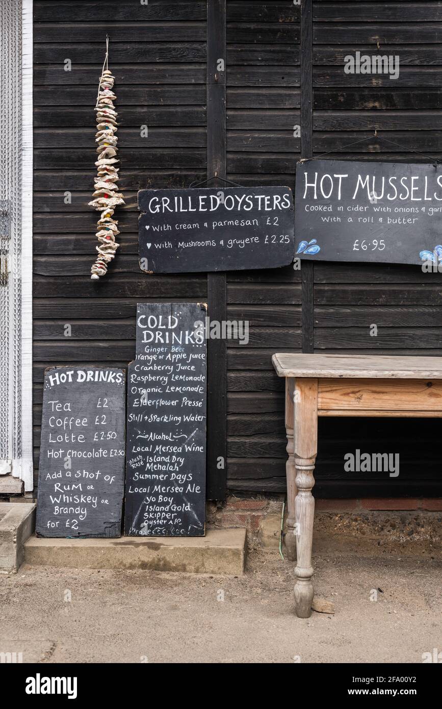 Essex Meeresfrüchte, Ansicht der Menütafeln außerhalb des Company Shed auf Mersea Island, einem lokalen Restaurant, das für seine frischen Meeresfrüchte bekannt ist, Mersea, Essex. Stockfoto