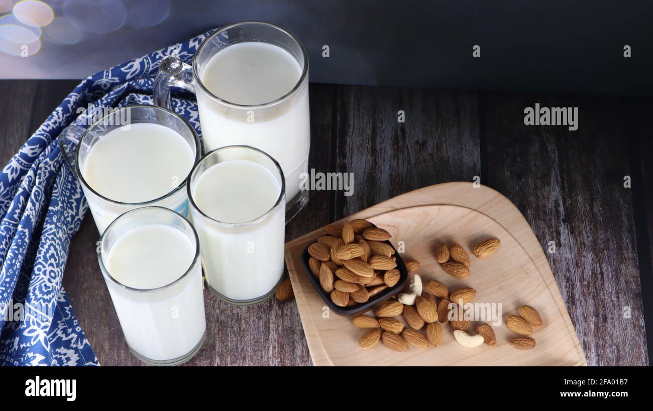 Kuhmilch, eine ausgezeichnete Quelle für Protein, beliebte Getränke, isoliert auf dunklem Hintergrund, Holzhintergrund Stockfoto