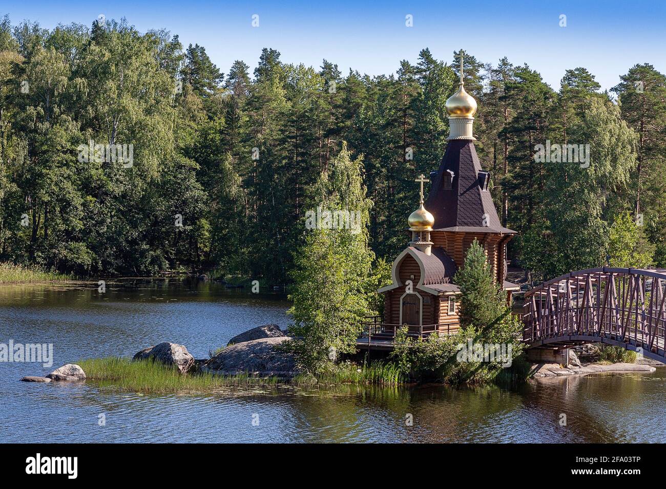 PRIOZERSK, RUSSIA-CIRCA Jun, 2018: Holzkirche von Andrew erstmals am Fluss Vuoksa benannt. Es ist eine kleine Kirche auf der Felsinsel in der Nähe des Dorfes Vasiljevo Stockfoto