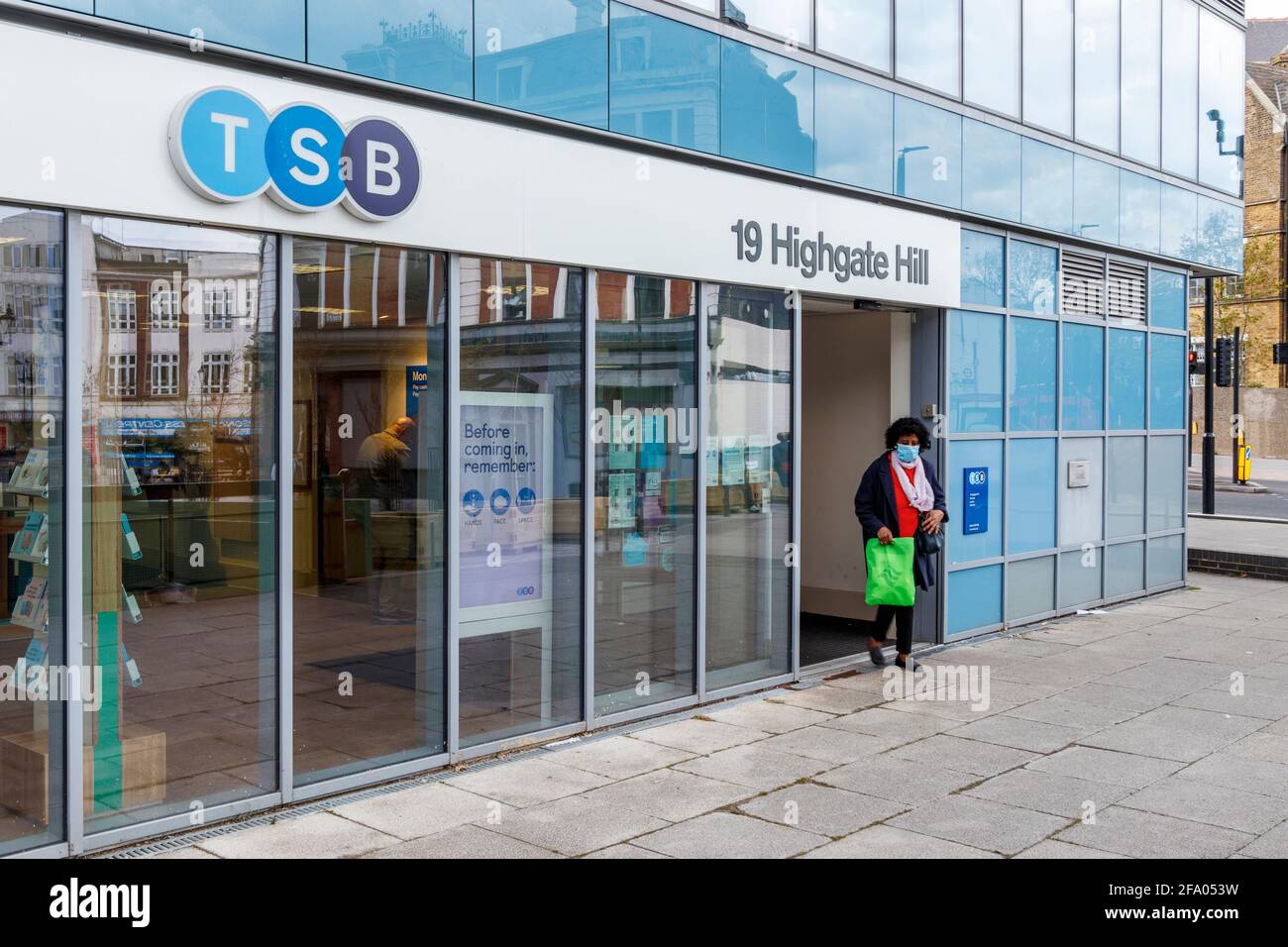 Eine Frau verlässt eine Zweigstelle der TSB-Bank in Archway, North Islington, London, Großbritannien Stockfoto
