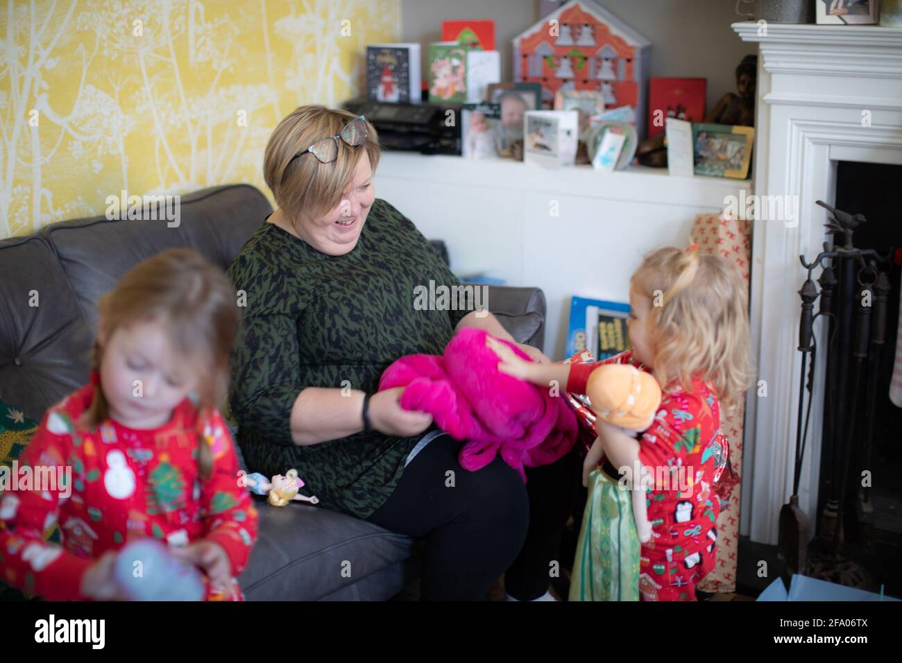 Eine Großmutter, die mit ihren beiden Enkelinnen den Weihnachtsfeiertag genießt. Stockfoto