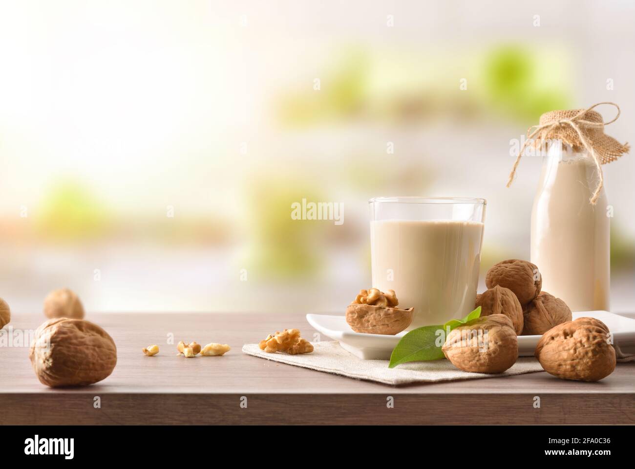 Glas und Flasche alternativen Gemüsegetränk Walnüsse mit Obst auf Holztisch in der Küche Stockfoto