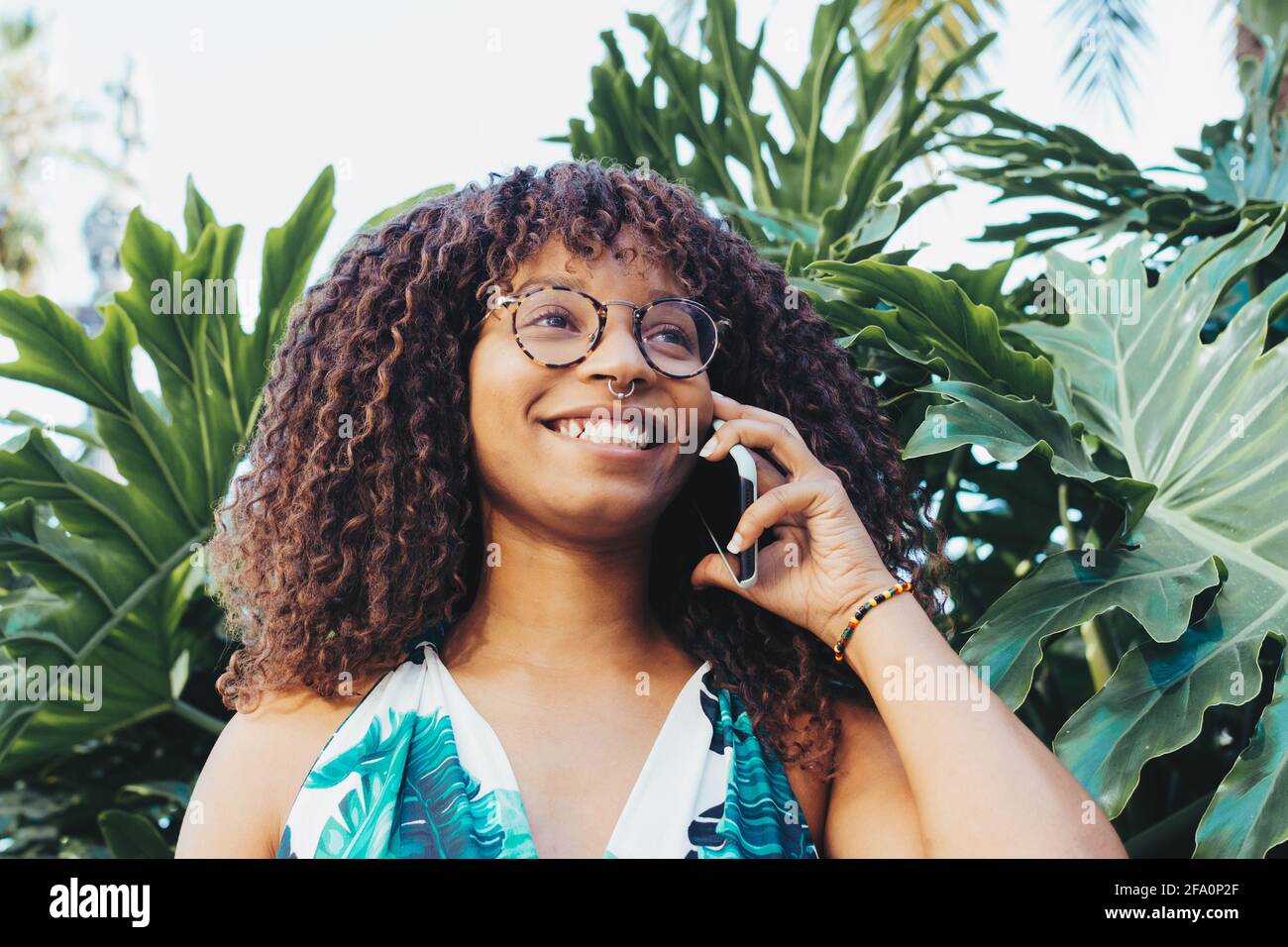 afrikanische junge Frau im Gespräch mit Handy in der Stadt Stockfoto