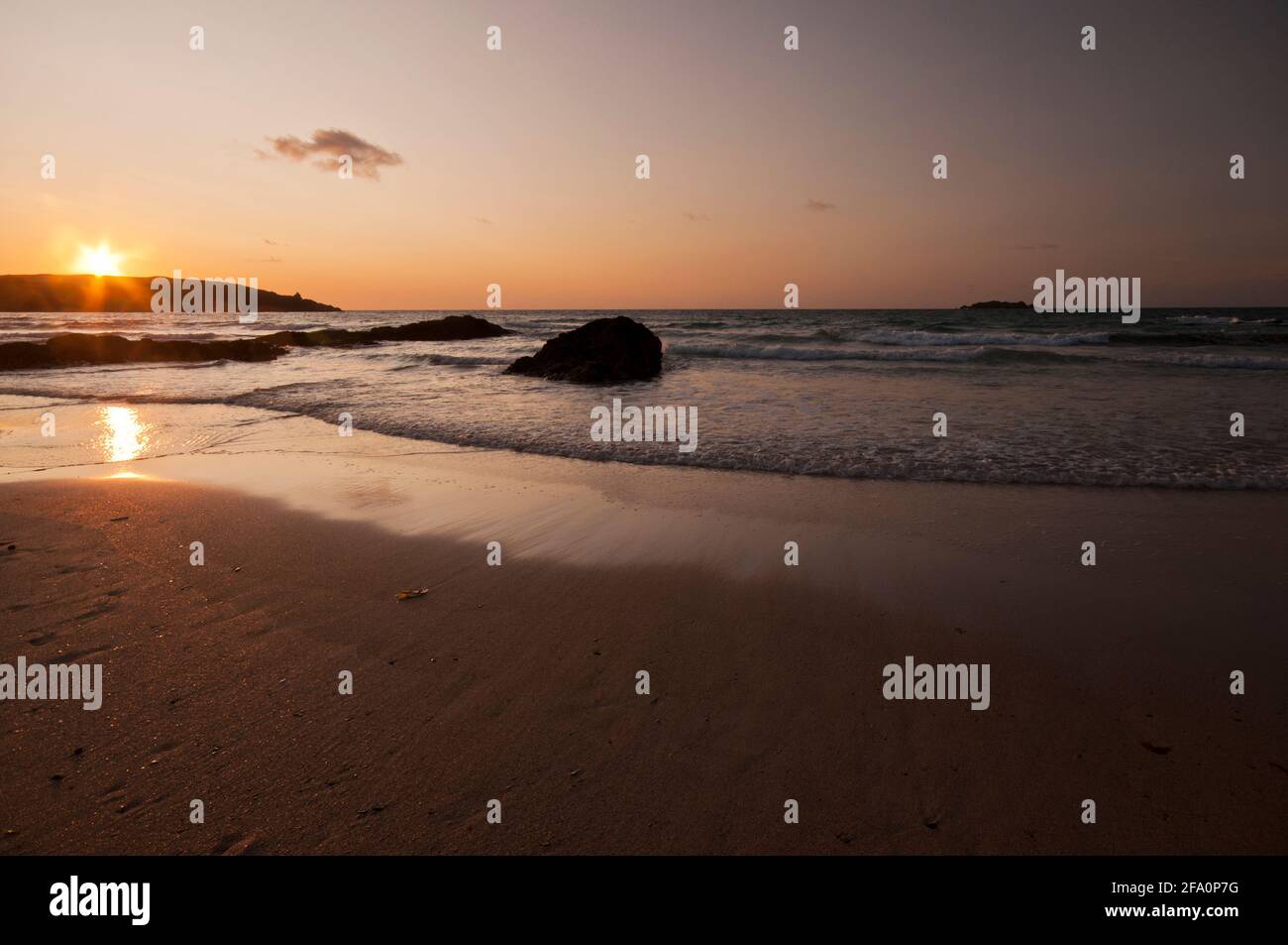 Sonnenuntergang von der Harlyn Bay in Cornwall. Der Strand liegt an der Küste Cornichs in der Nähe von Padstow und ist ein beliebter Strand für Urlauber und Surfer. Stockfoto