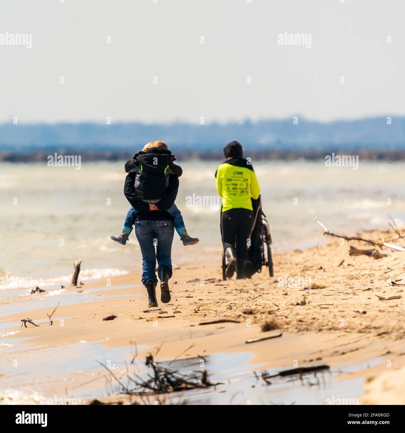 Zwei junge Mütter, die an einem kalten Frühlingsnachmittag mit ihren Kindern am Strand entlang spazieren. Teil des zwei-Länder-Abschnitts des nationalen Ice Age Trail Stockfoto