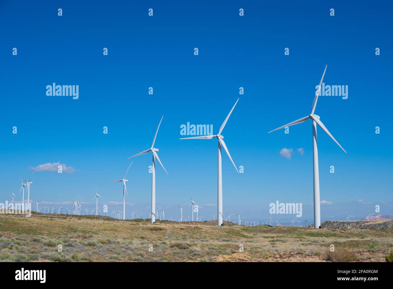 In den Bergen über Los Angeles, Kalifornien, werden in der Nähe von Häusern Windkraftanlagen betrieben Stockfoto