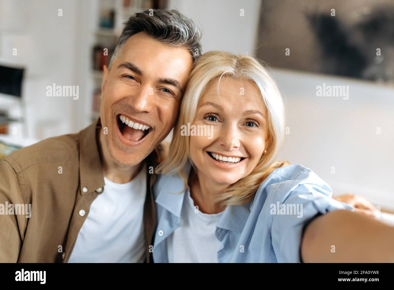 Porträt der schönen fröhlichen Ehe reifes Paar in legerer Kleidung, kaukasischen Mann und Frau Selfie auf dem Smartphone, Spaß zusammen, Blick auf die Kamera, lächelnd Stockfoto