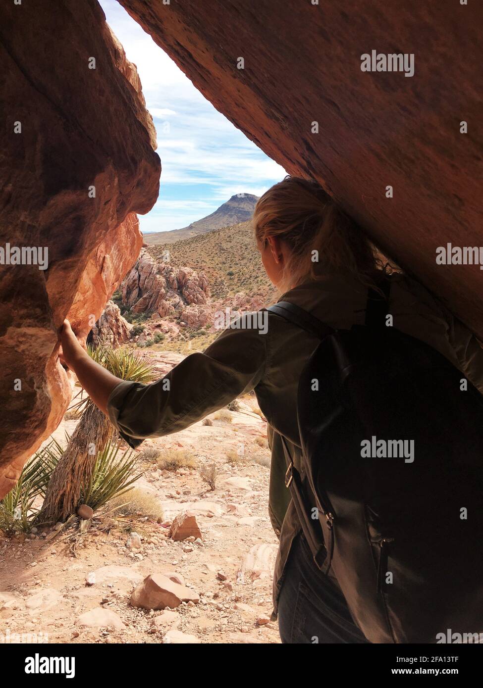 Frau, die aus einer Höhle im Red Rock Canyon in Las Vegas, Nevada, blickt. Reisekonzept, Erlebniskonzept. Stockfoto
