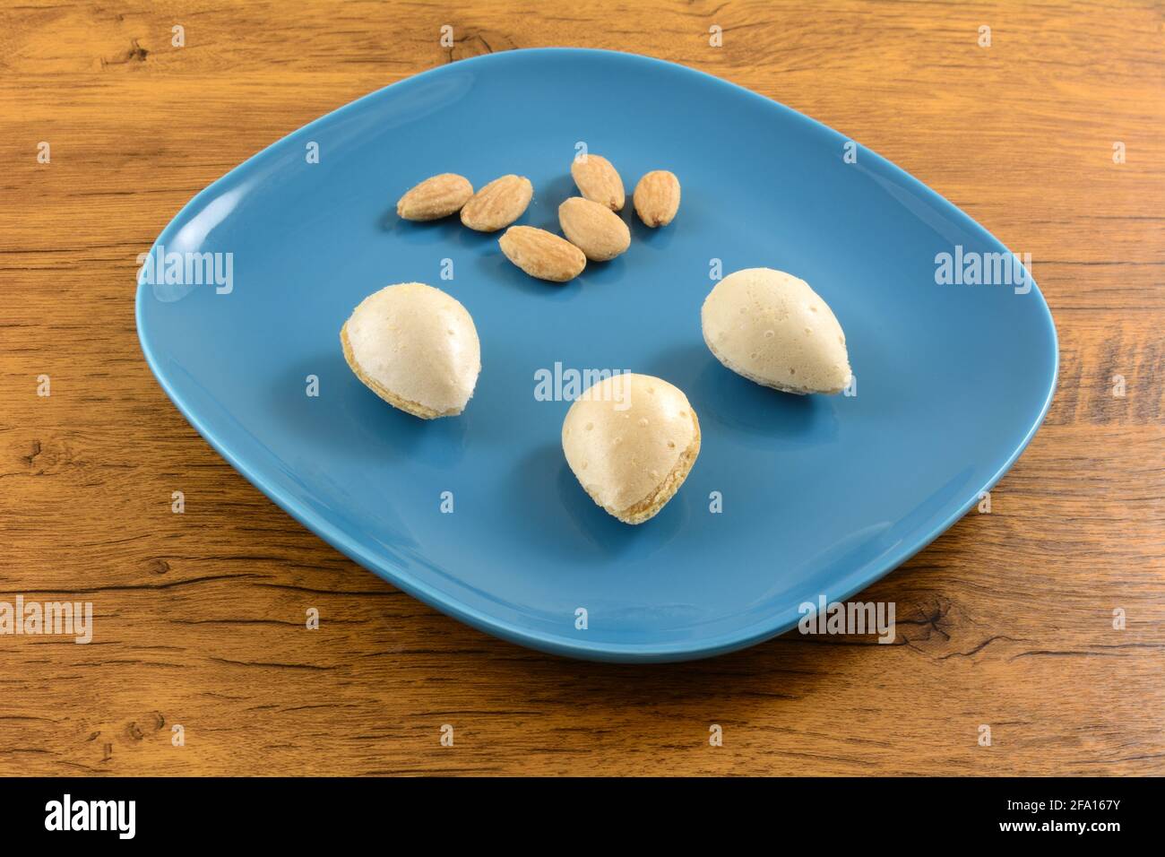 Mandelcreme-Waffelplätzchen mit Mandeln auf blauem Snackteller Stockfoto
