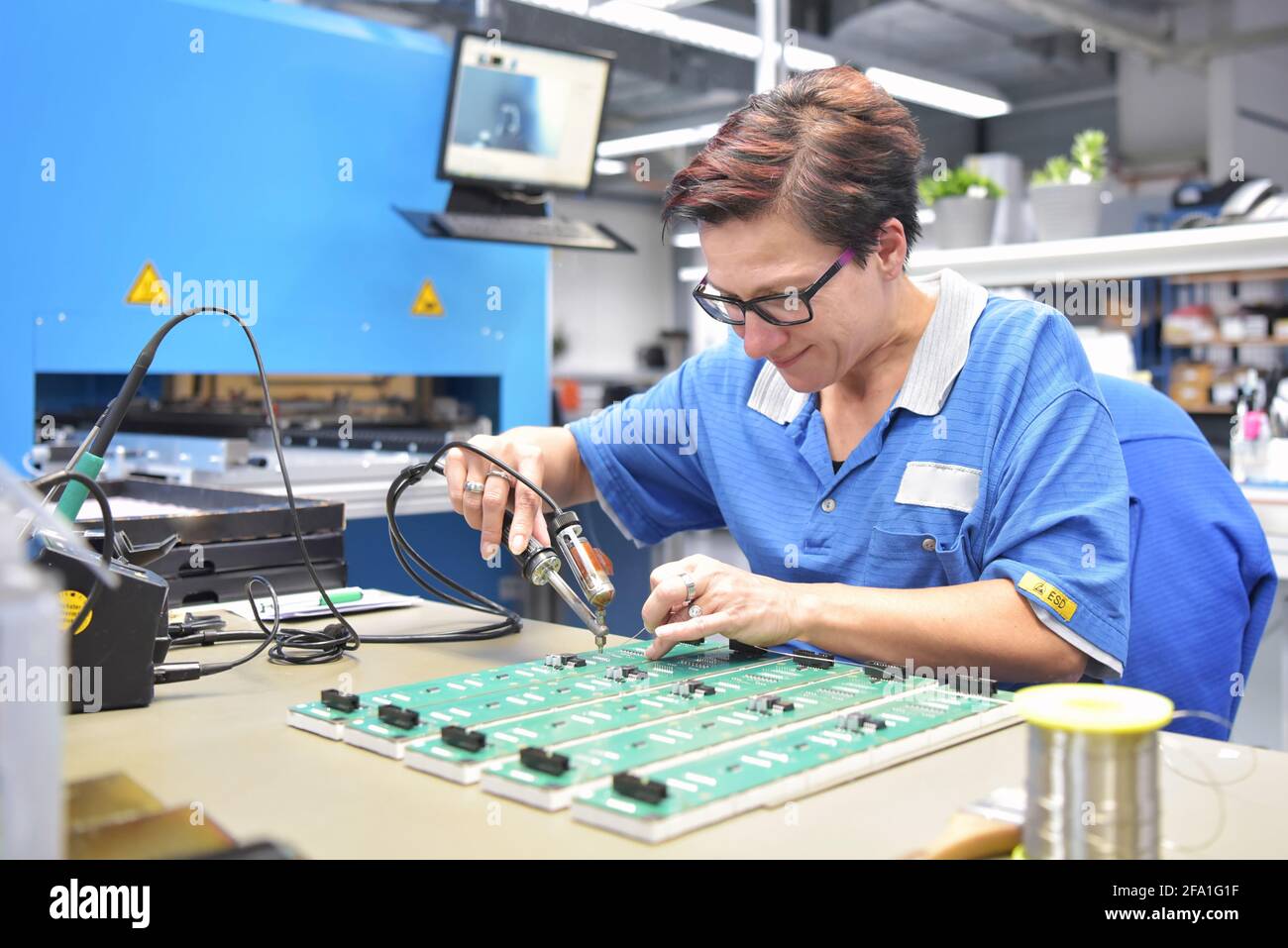 Freundliche Frau in einem mikroelektronikfertigung Factory-Komponenten Montage und Löten arbeiten Stockfoto