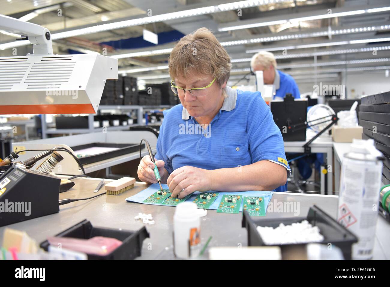 Freundliche Frau in einem mikroelektronikfertigung Factory-Komponenten Montage und Löten arbeiten Stockfoto