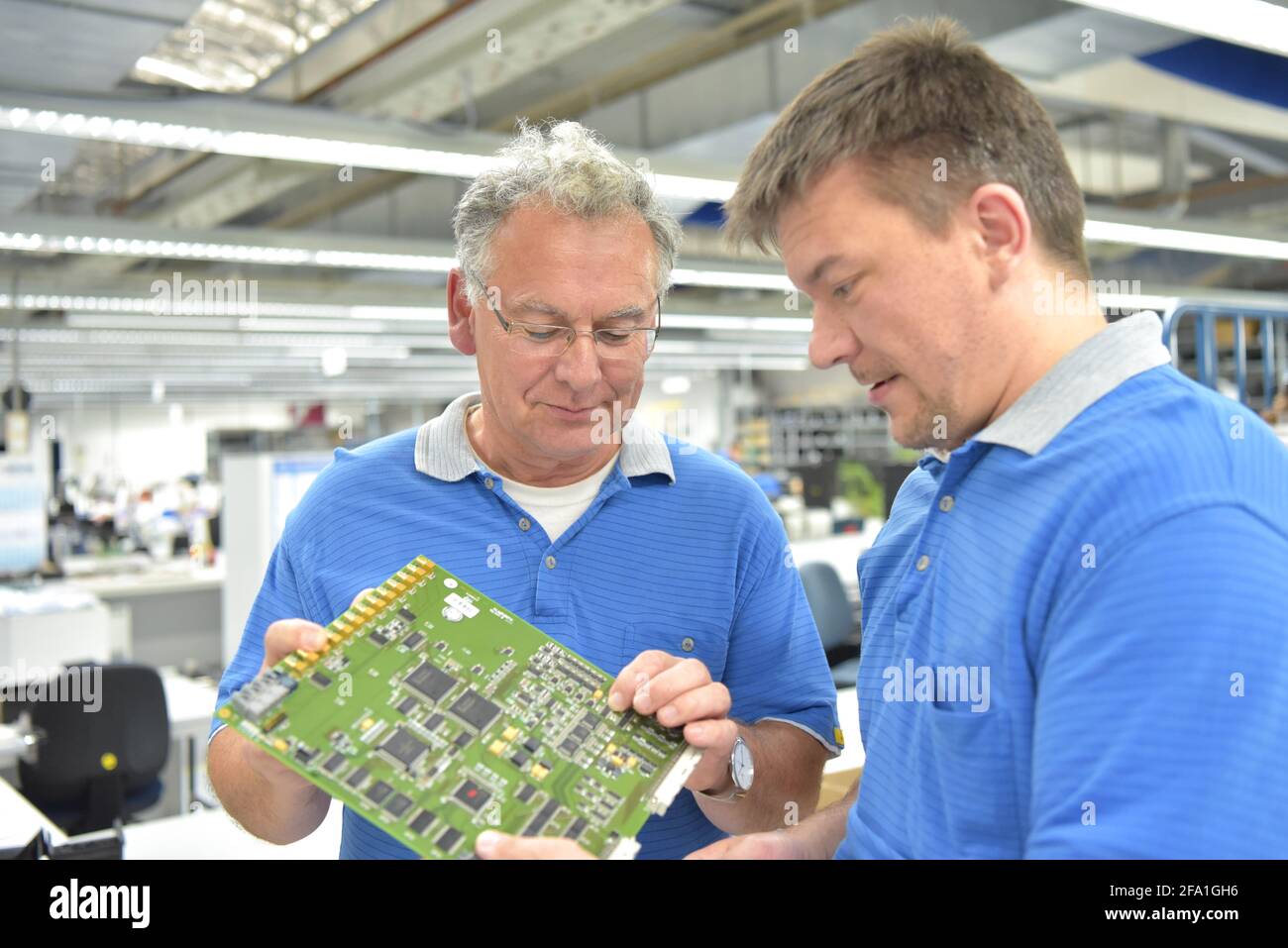 Qualitätskontrolle im Engineering in Teamarbeit - Mitarbeiter bei einer Sitzung - Herstellung von Elektronik in einem modernen industriellen Fabrik Stockfoto