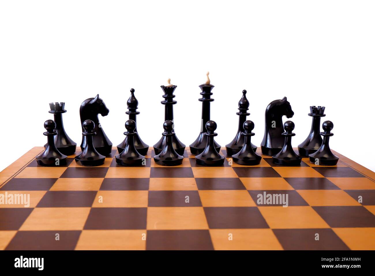 Schwarze Schachfiguren stehen auf einem Schachbrett. Stockfoto