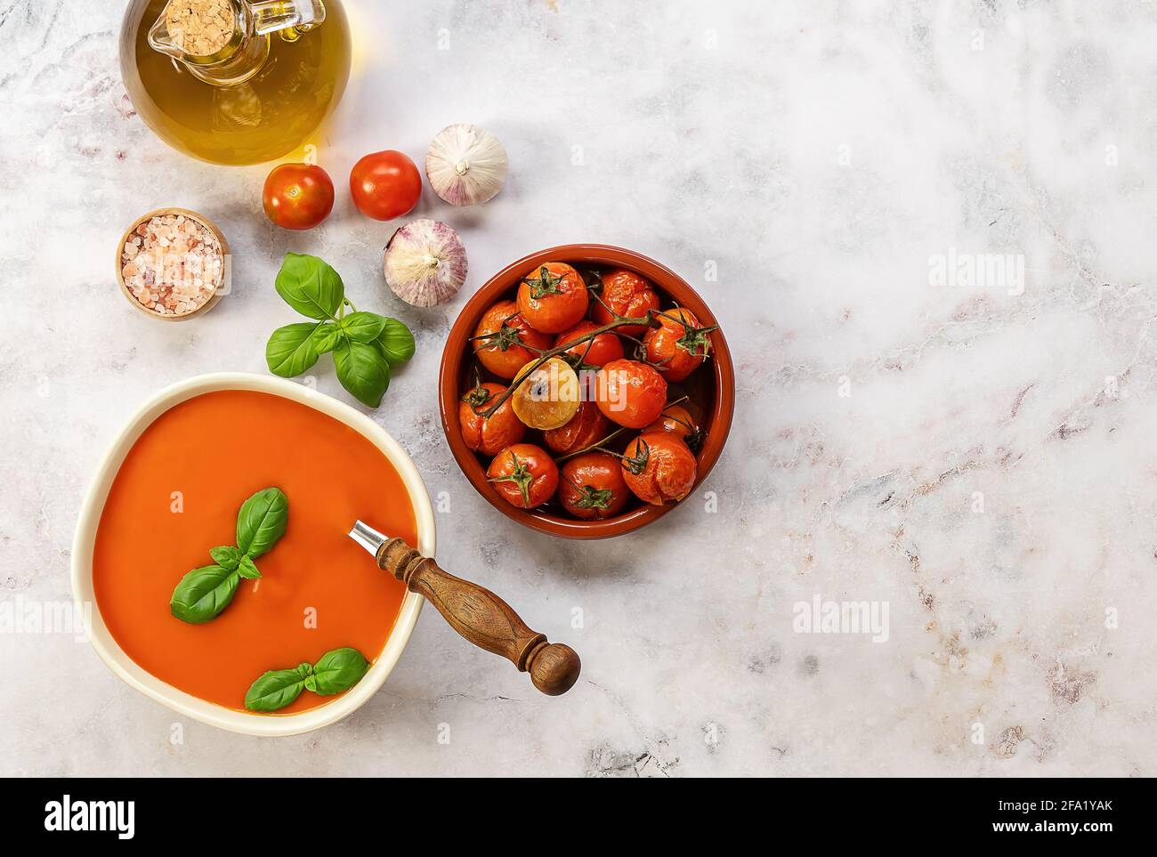 Schüssel Tomatensahnesuppe mit gerösteter Kirsche und Knoblauch. Vegetarisches Rezept, gesundes Mittagessen. Draufsicht, Platz kopieren Stockfoto